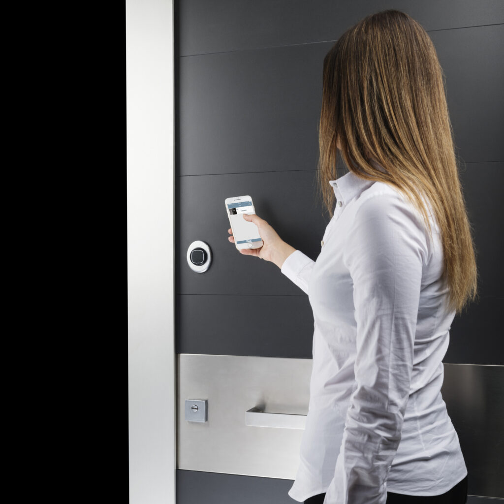Donna che apre la serratura elettronica Smart della porta blindata Invisio.